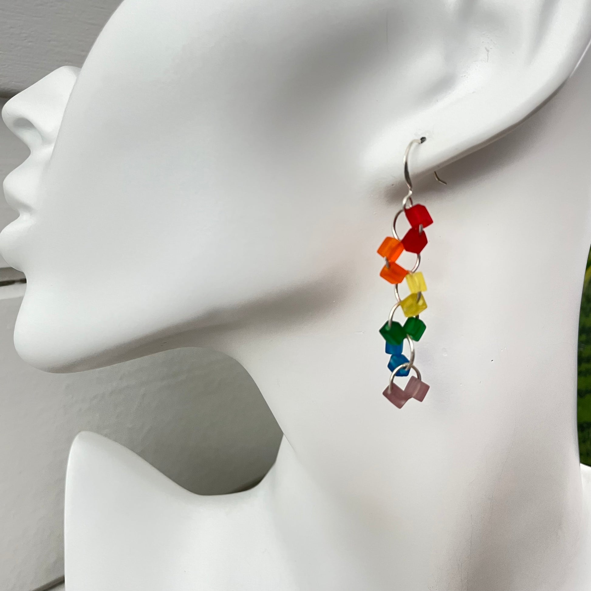 Rainbow Frosted Glass Geometric Link Dangle Earrings 2" LGBTIA Hand Crafted Colorful Ally Pride Flag--closse up view of single earring on solid white mannequin