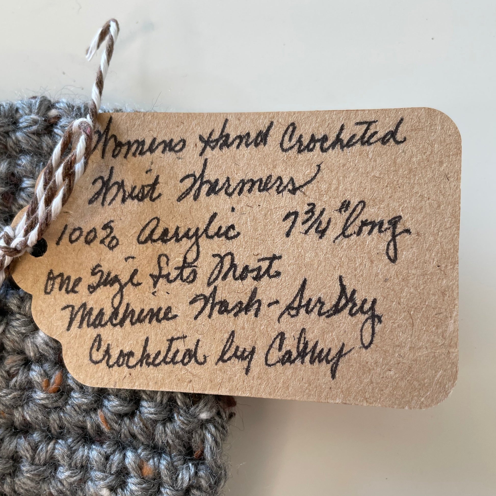 close up of handwritten wrist warmer tag--details in description
