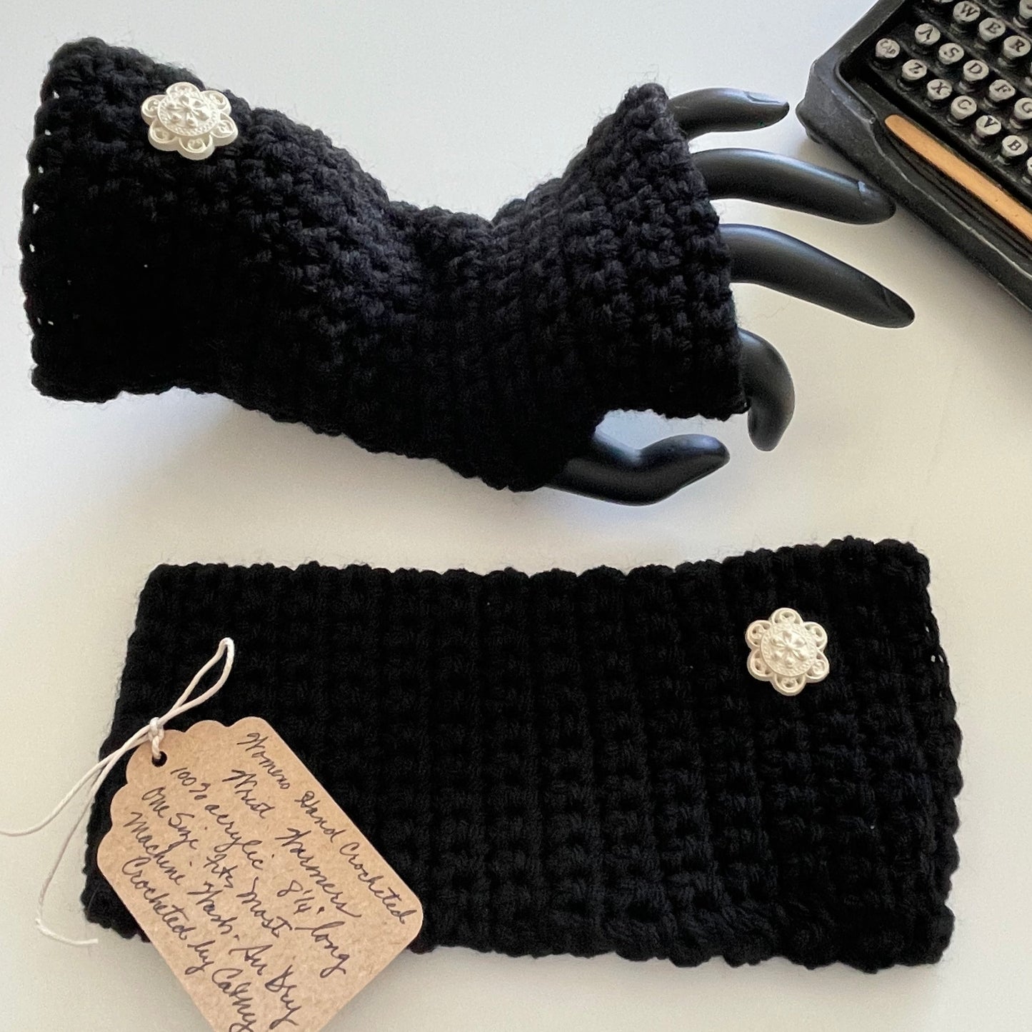 Texting Tech Wrist Warmers Solid Black Ivory Cream Flower Button Crochet Knit Fall Winter Writing Gaming Fingerless Gloves Embellished photo of one glove modeled on acrylic hand, the other flat on table