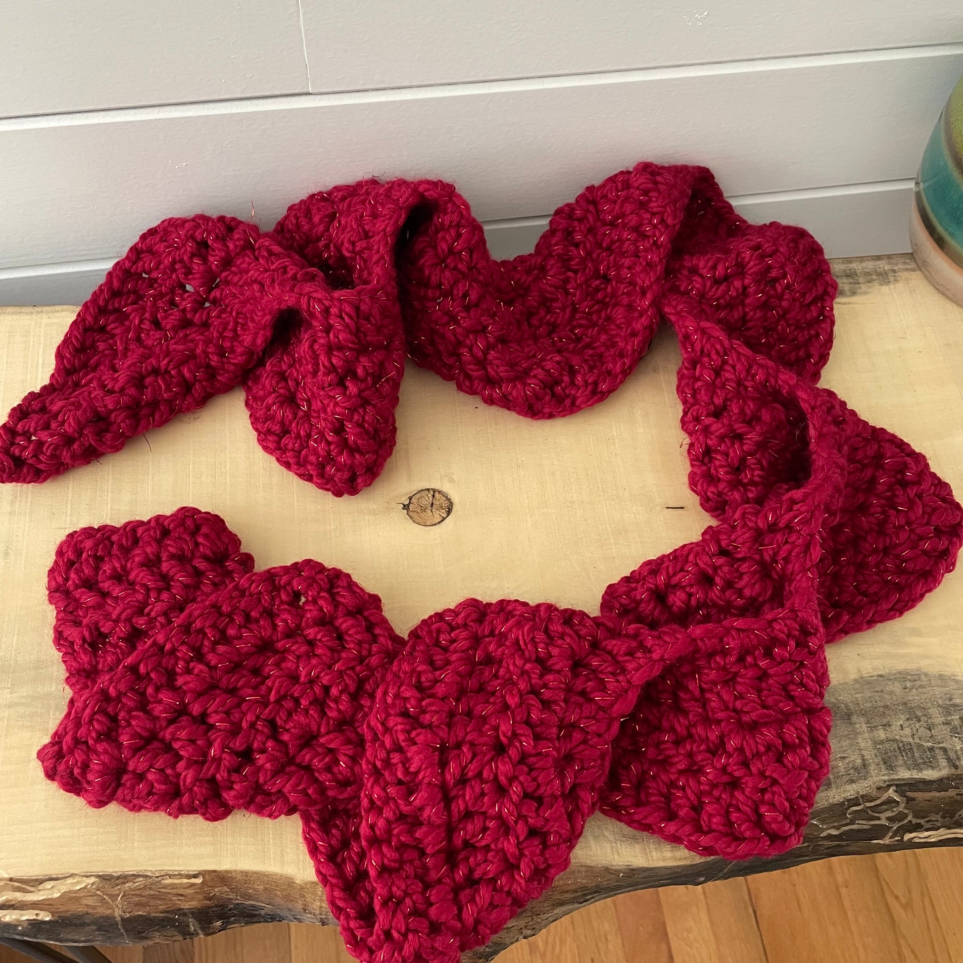 Extra Warm Crochet Knit Chunky Ruffled Scarf Hand Crafted Marbled Red Wine Maroon Metallic Accent Flirty Fall Winter--featured on a natural light wood table