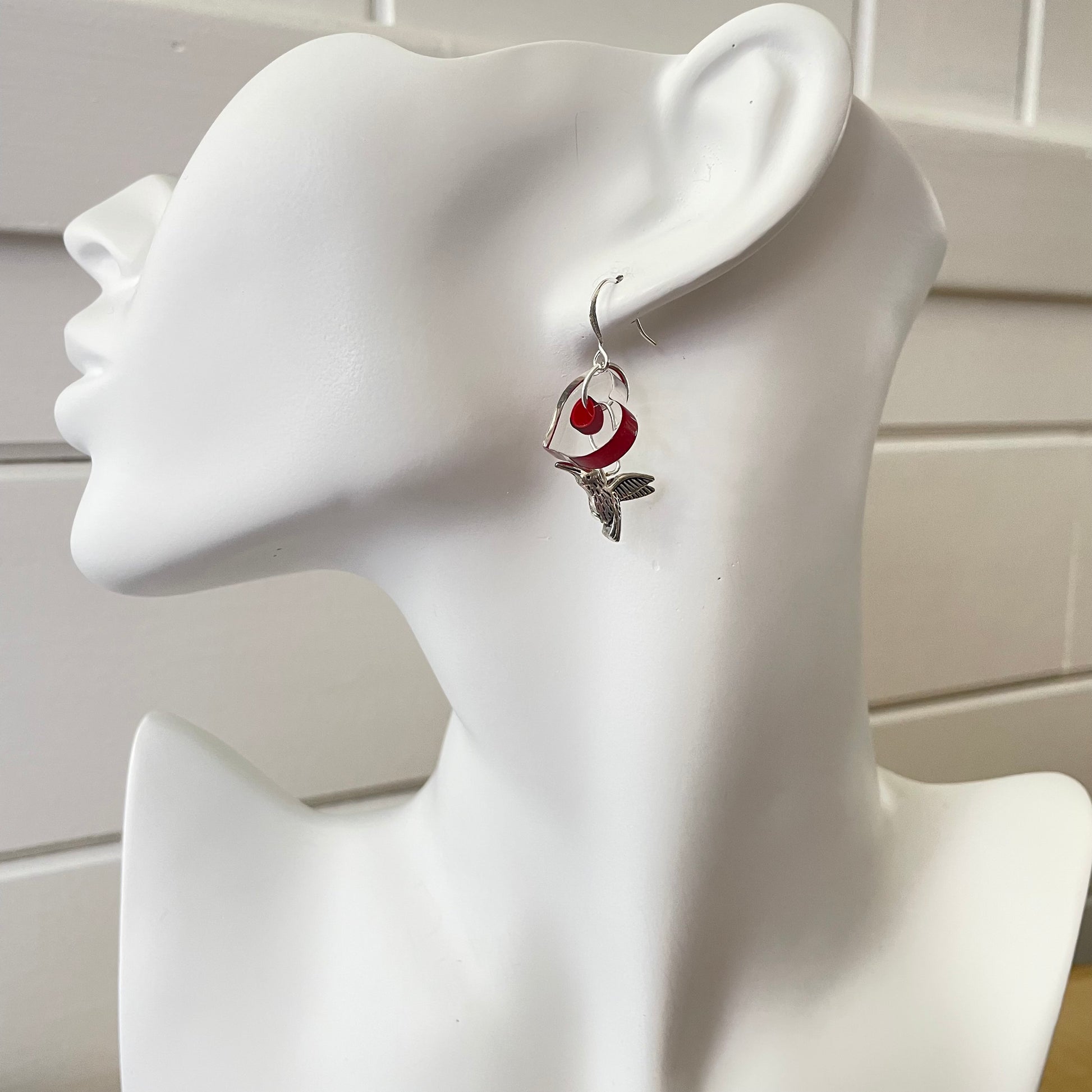 single earring displayed on white mannequin Handmade Antiqued Hummingbird & Cain Glass Heart Dangle Earrings 1.5" Red Black Clear Love Valentine's Bird