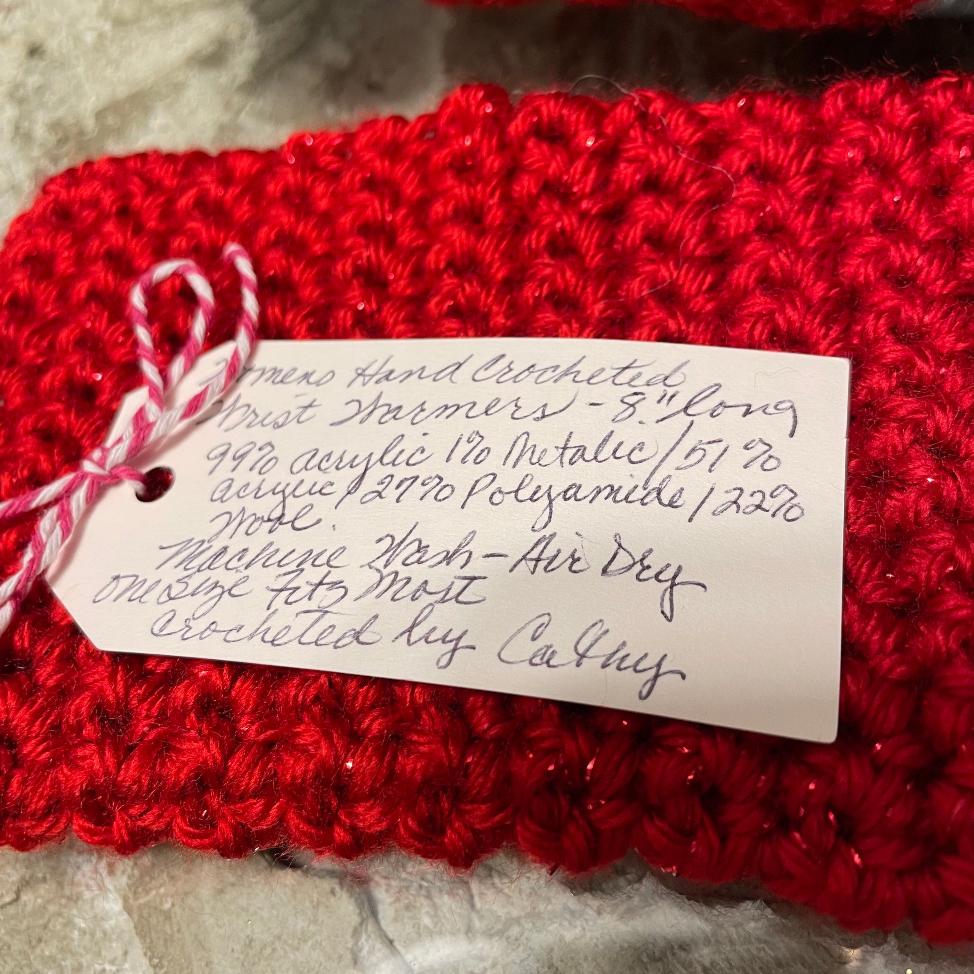 closeup of tag--8" long, material content (details in product description), machine wash/air dry, one size fits most