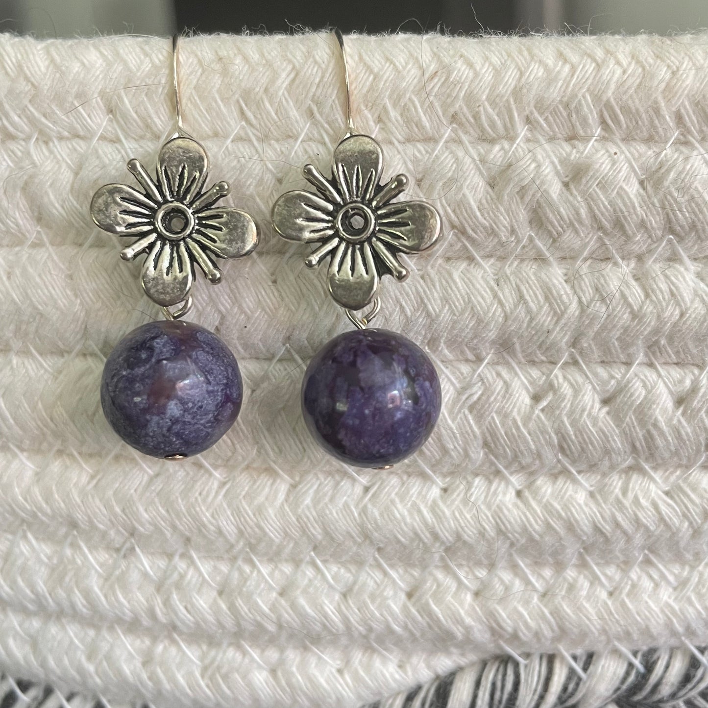 Antiqued Flower & Dark Purple Marbled Jasper Drop Earrings 1.5" close up against ivory woven textile